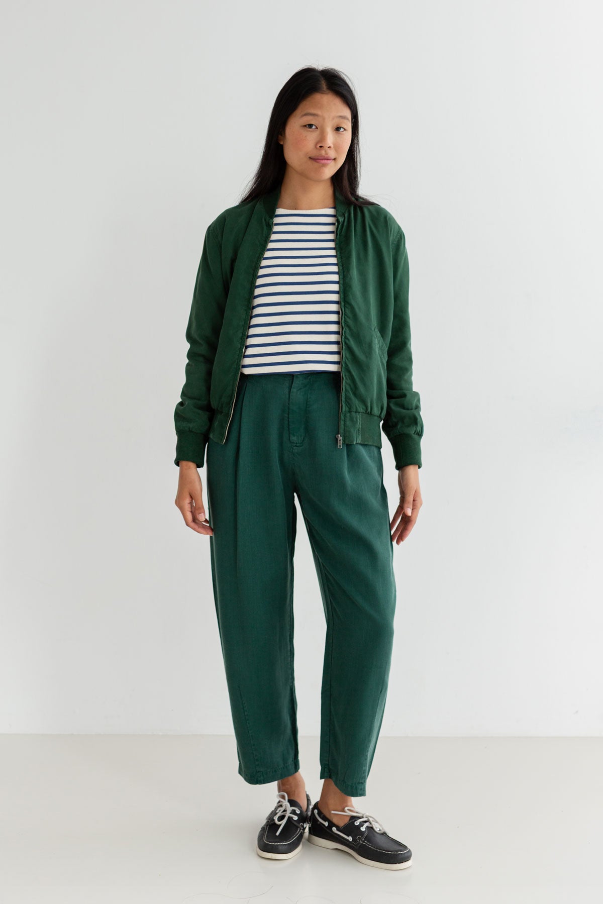 Dark green bomber jacket women striped tshirt green pants full body view front