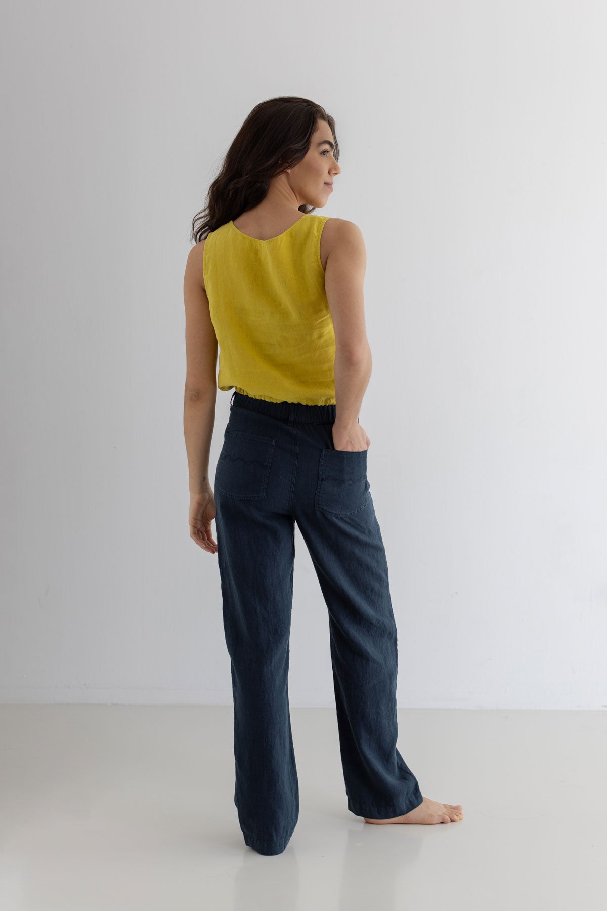 Golden green sleeveless linen shirt women navy blue pants full body view back
