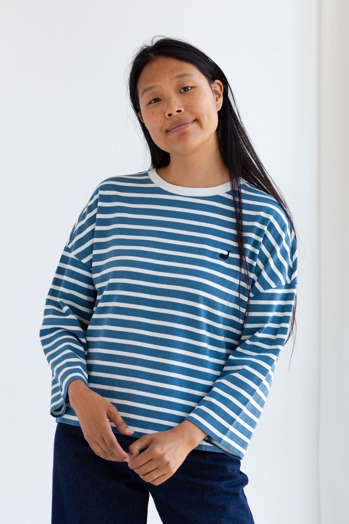 Woman wearing a dusty blue and white striped long-sleeve shirt.
