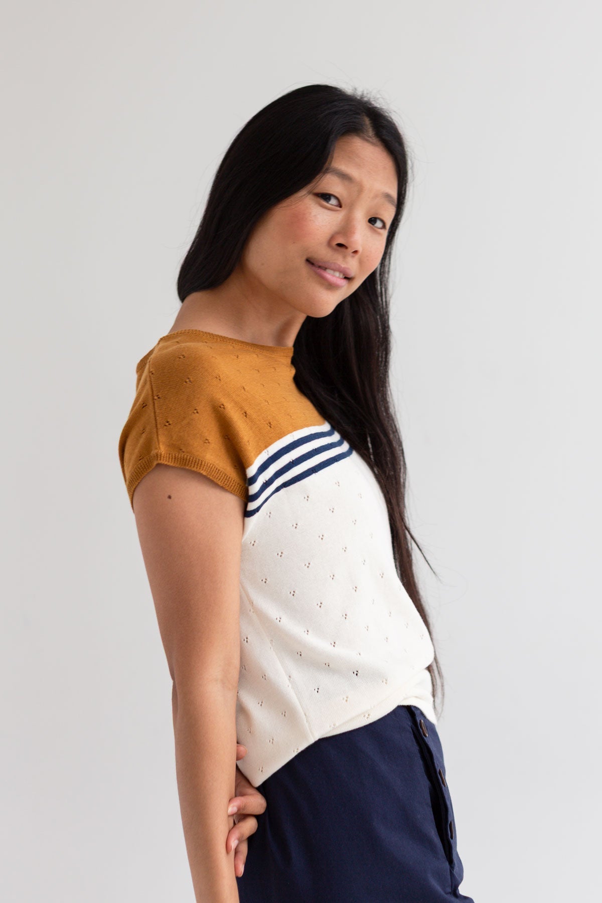 Ecru mustard knit top women navy pants side view