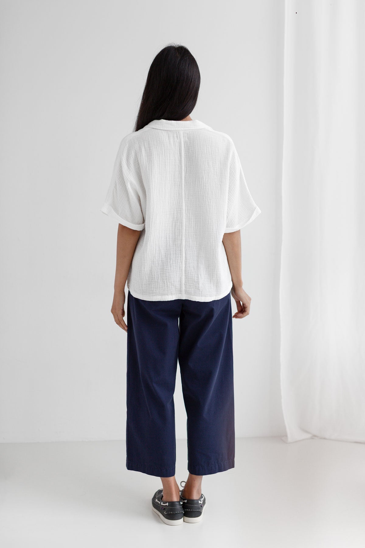 Off white muslin shirt women navy pants full body view back