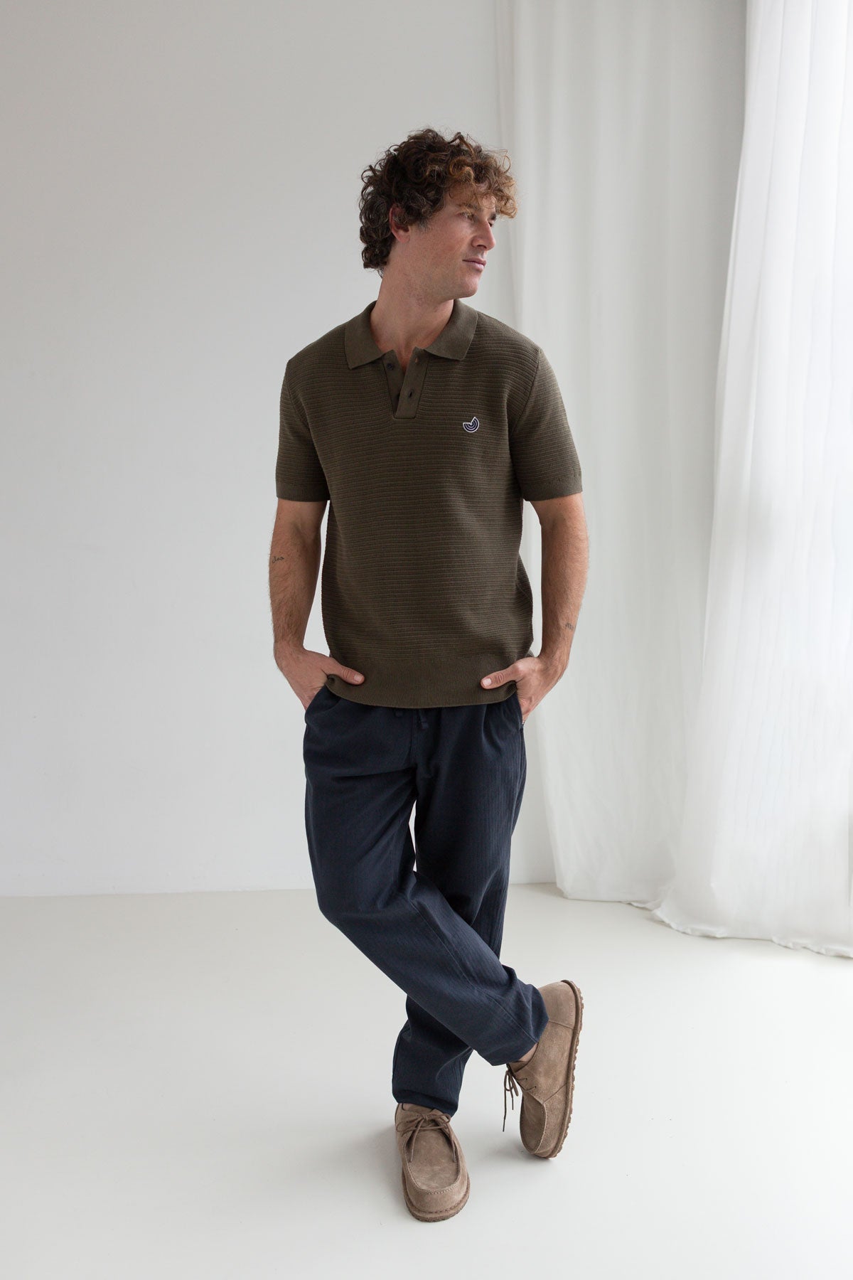 Khaki knit polo shirt men navy pants full body view front 