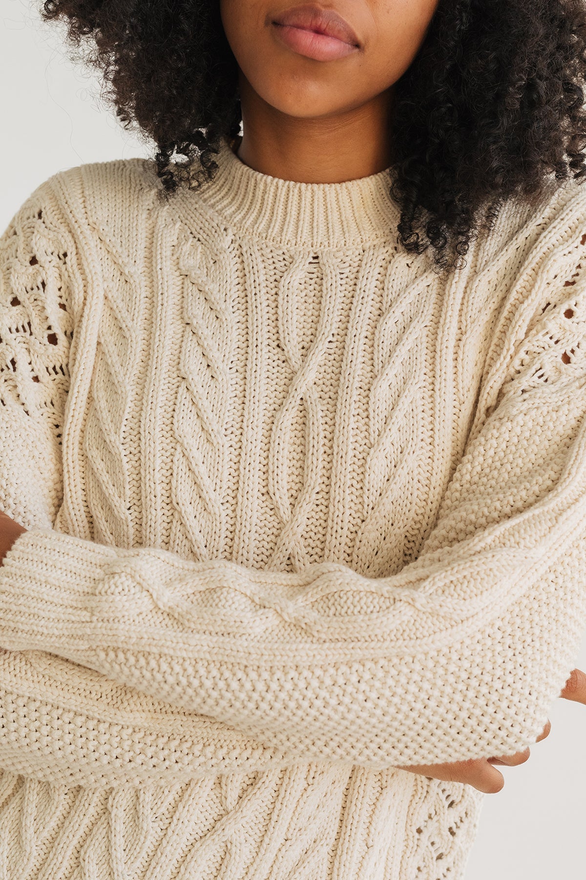 model wearing ecru knit with openwork detailing in organic cotton.